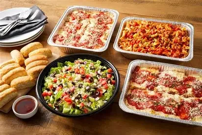 Italian pasta dishes with salad and breadsticks