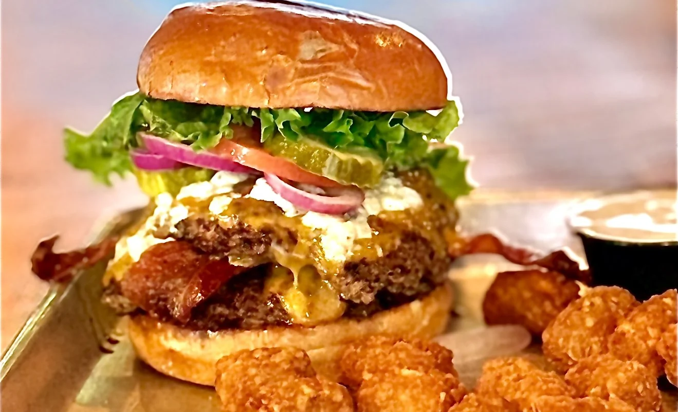 Delicious gourmet burger with fresh toppings on a wooden table