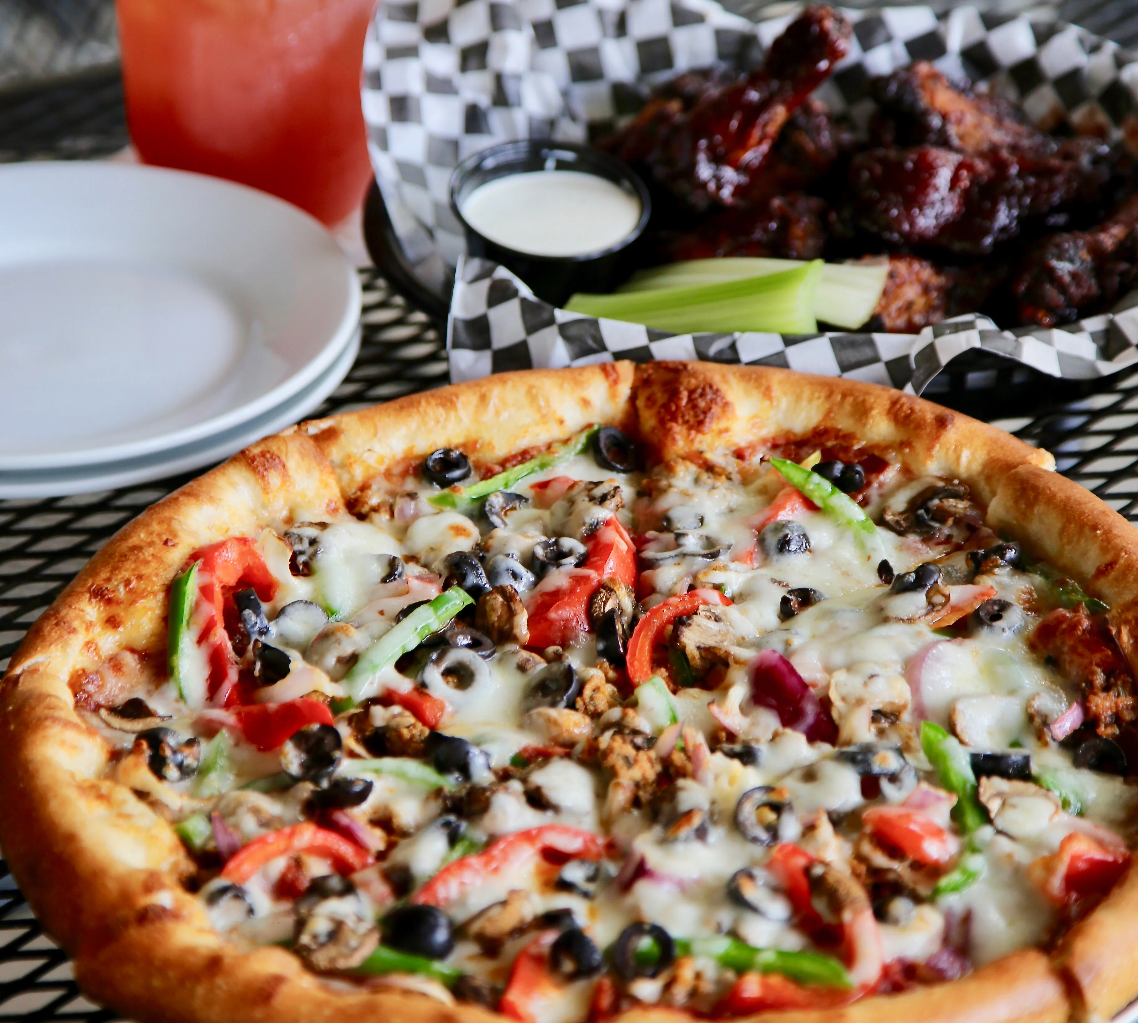 Delicious pepperoni pizza with wings and a refreshing cocktail