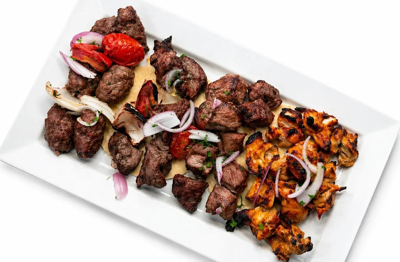 Mixed grill platter featuring kebabs and grilled vegetables