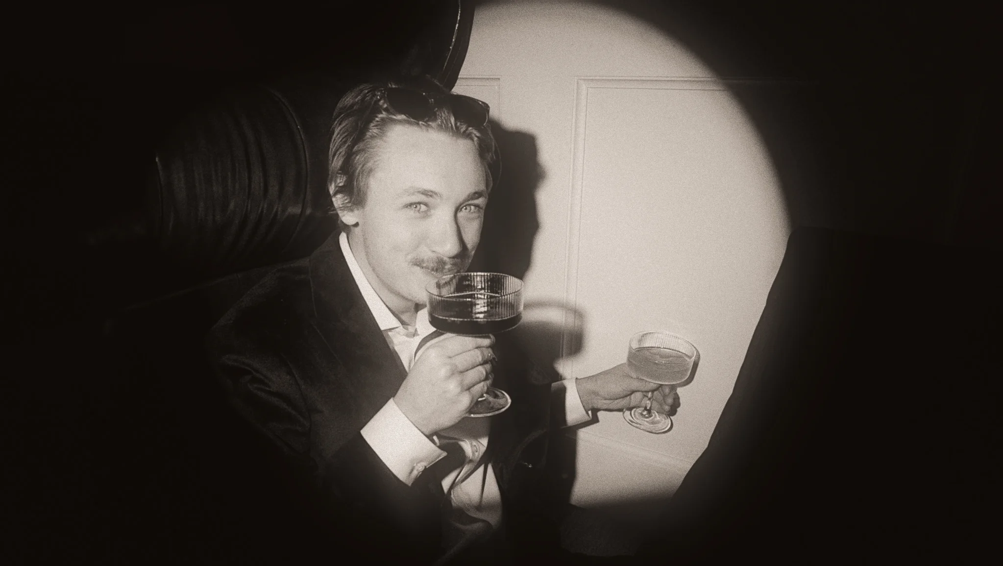 Vintage portrait of a well-dressed guest enjoying cocktails in an elegant lounge