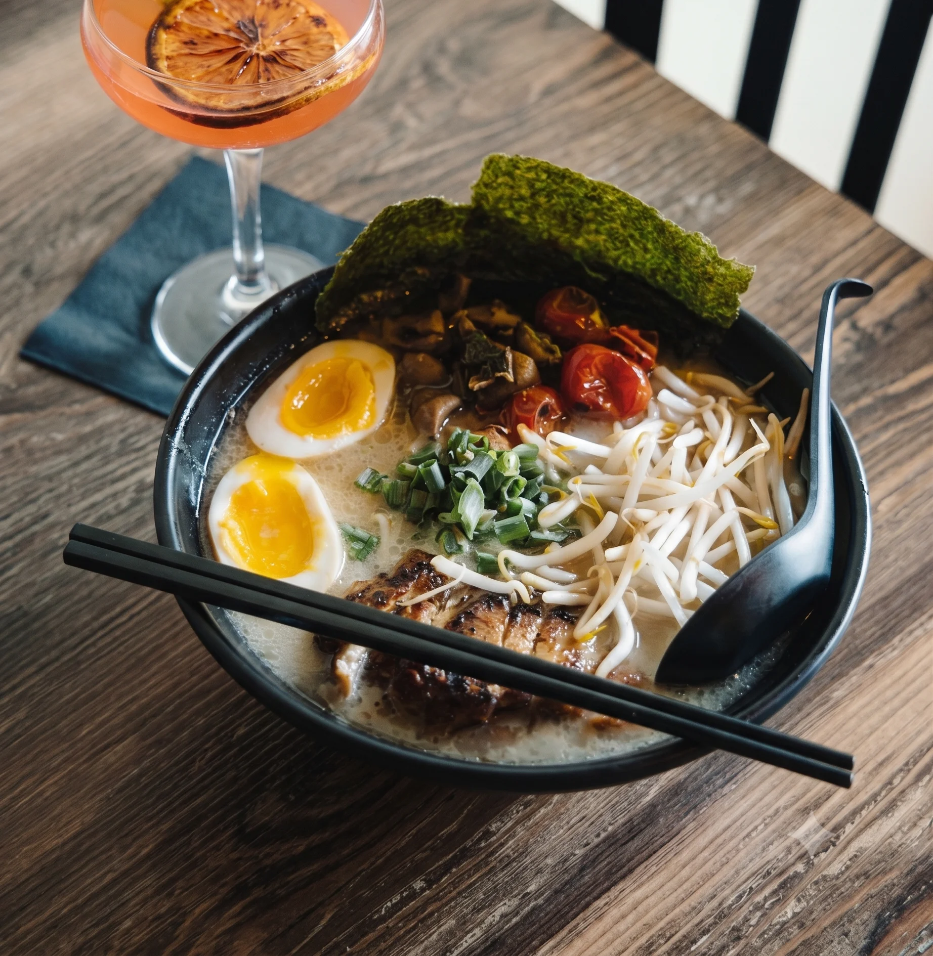 Japanese tonkotsu ramen with soft-boiled eggs and a cocktail