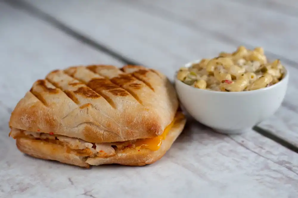 The Poeta has deli sliced turkey, Tillamook cheddar, roasted garlic and sun-dried tomato aioli on our grilled ciabatta. Serve it up with our macaroni salad