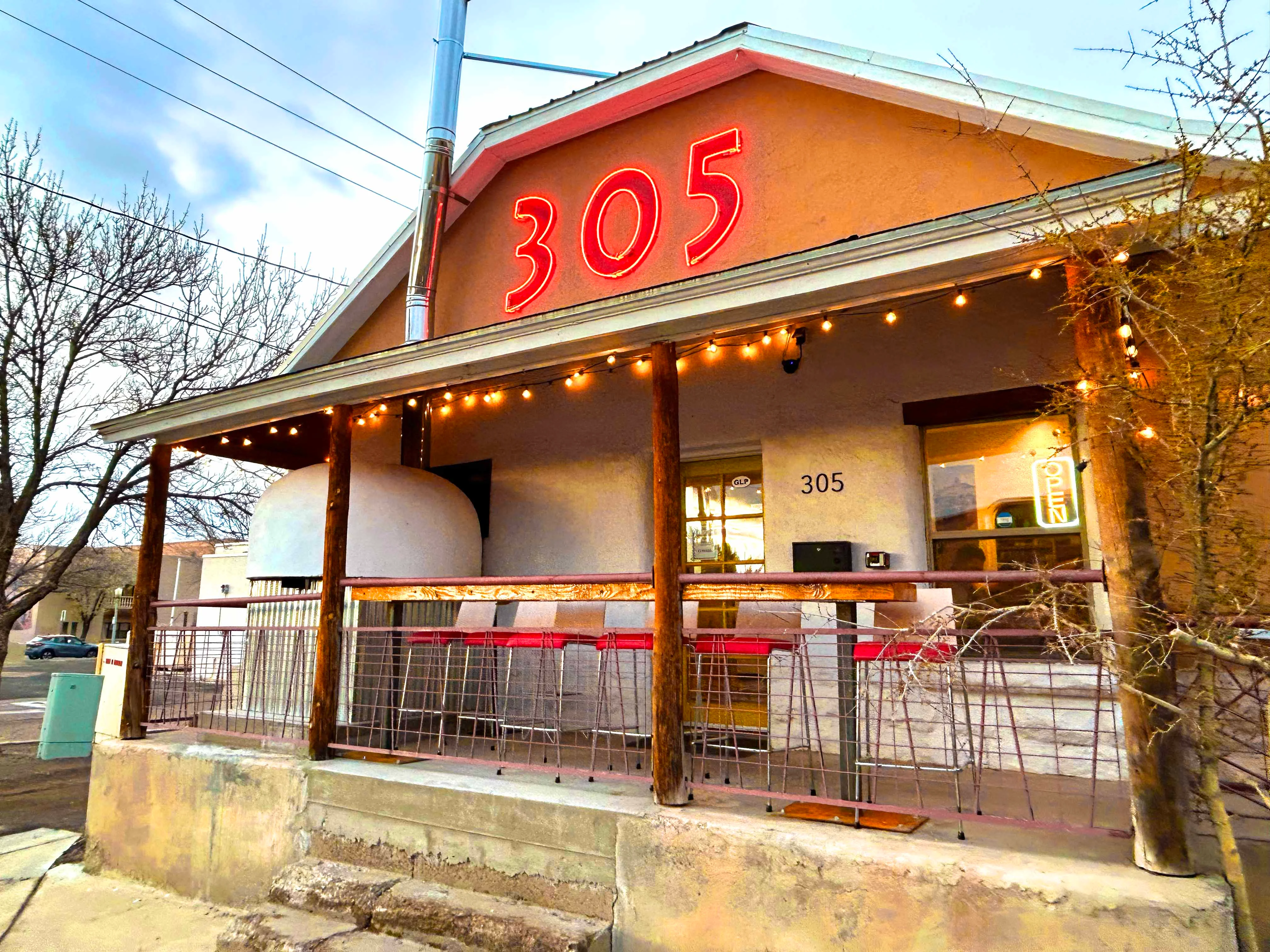 Charming restaurant exterior with neon sign and outdoor seating