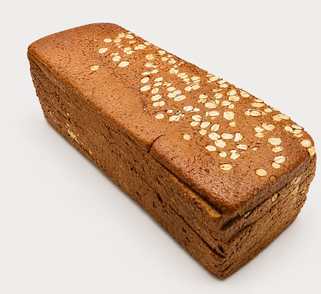 Loaf of bread topped with oats, showcasing a rustic appearance.