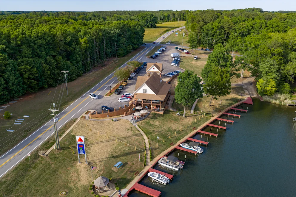 Aerial view of a lakeside restaurant with parking and boats docked.