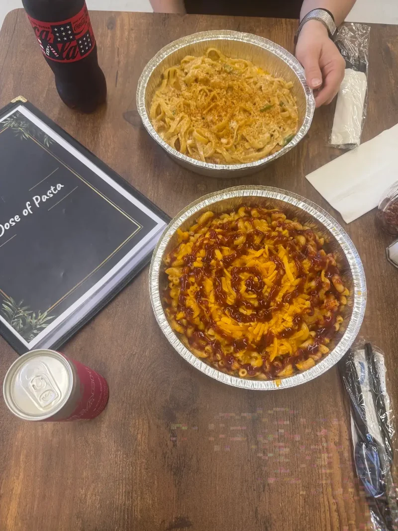 Two pasta dishes with a menu on a wooden table