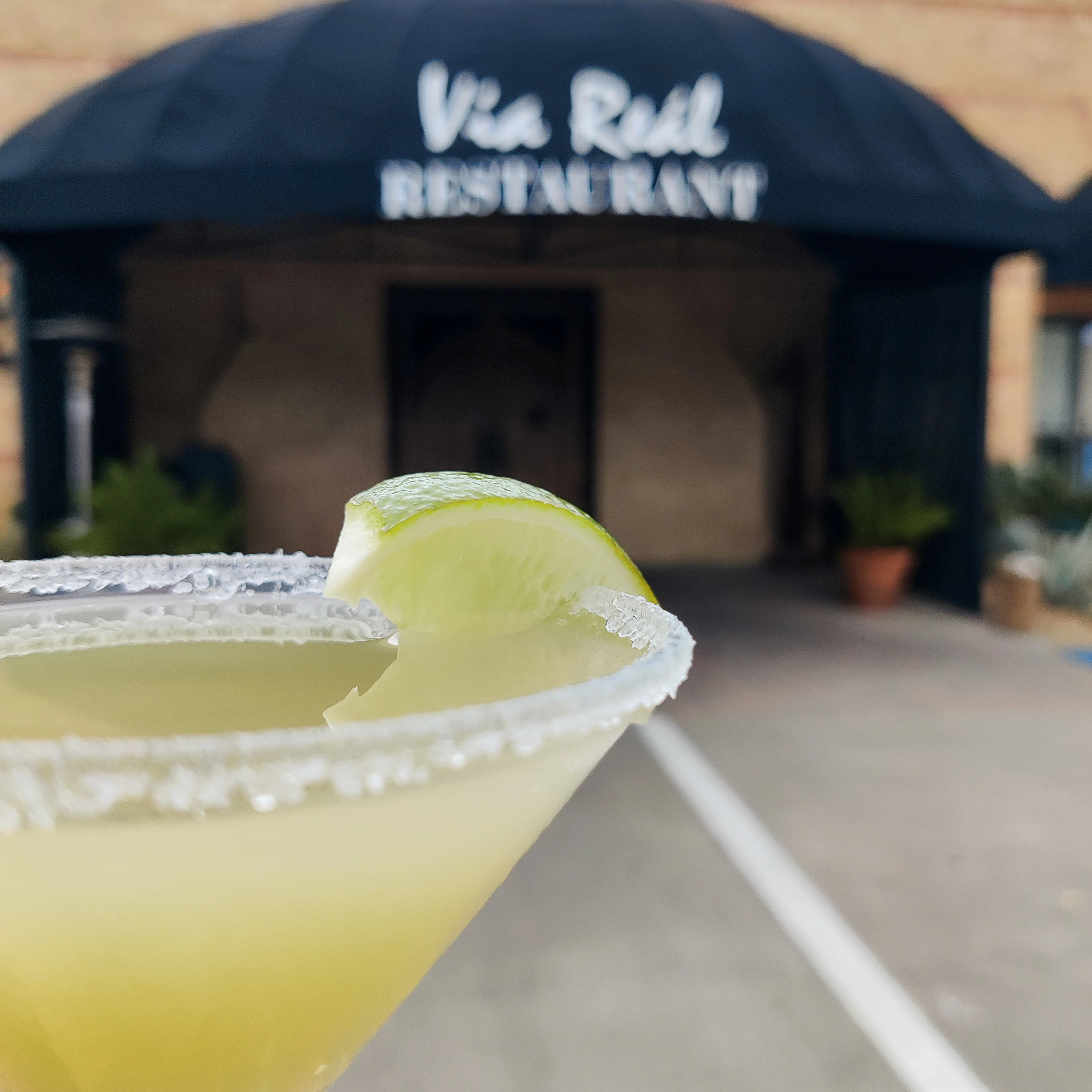 Refreshing margarita cocktail at a restaurant entrance