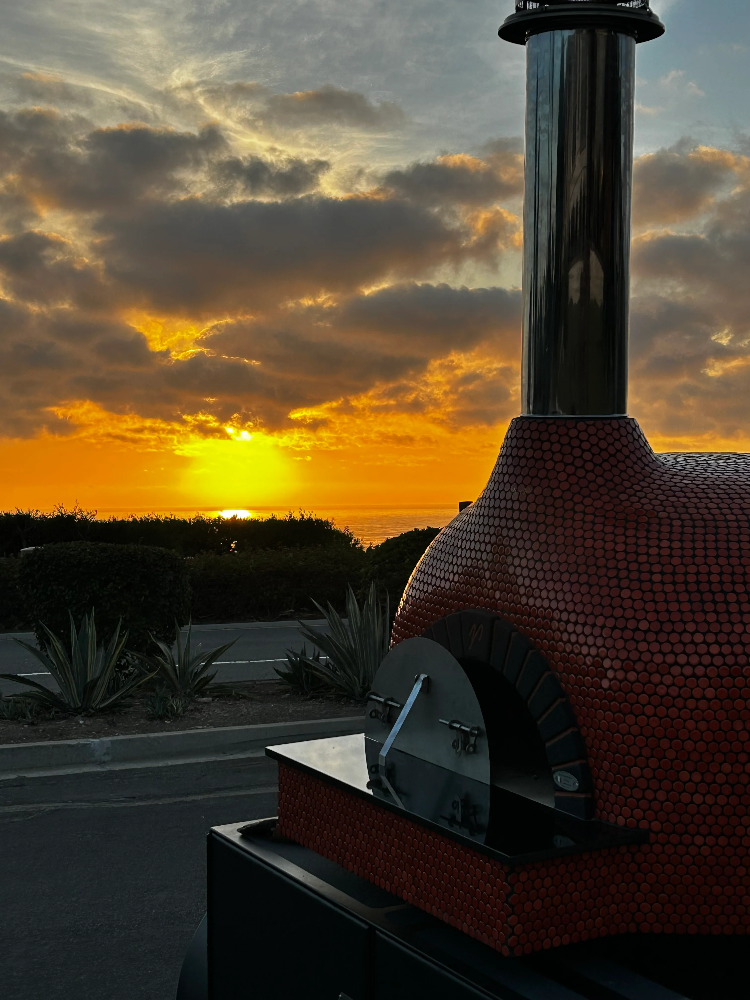 A sunset in the background of a pizza oven