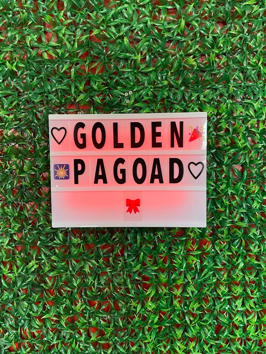 Restaurant sign for Golden Pagoad with decorative greenery background