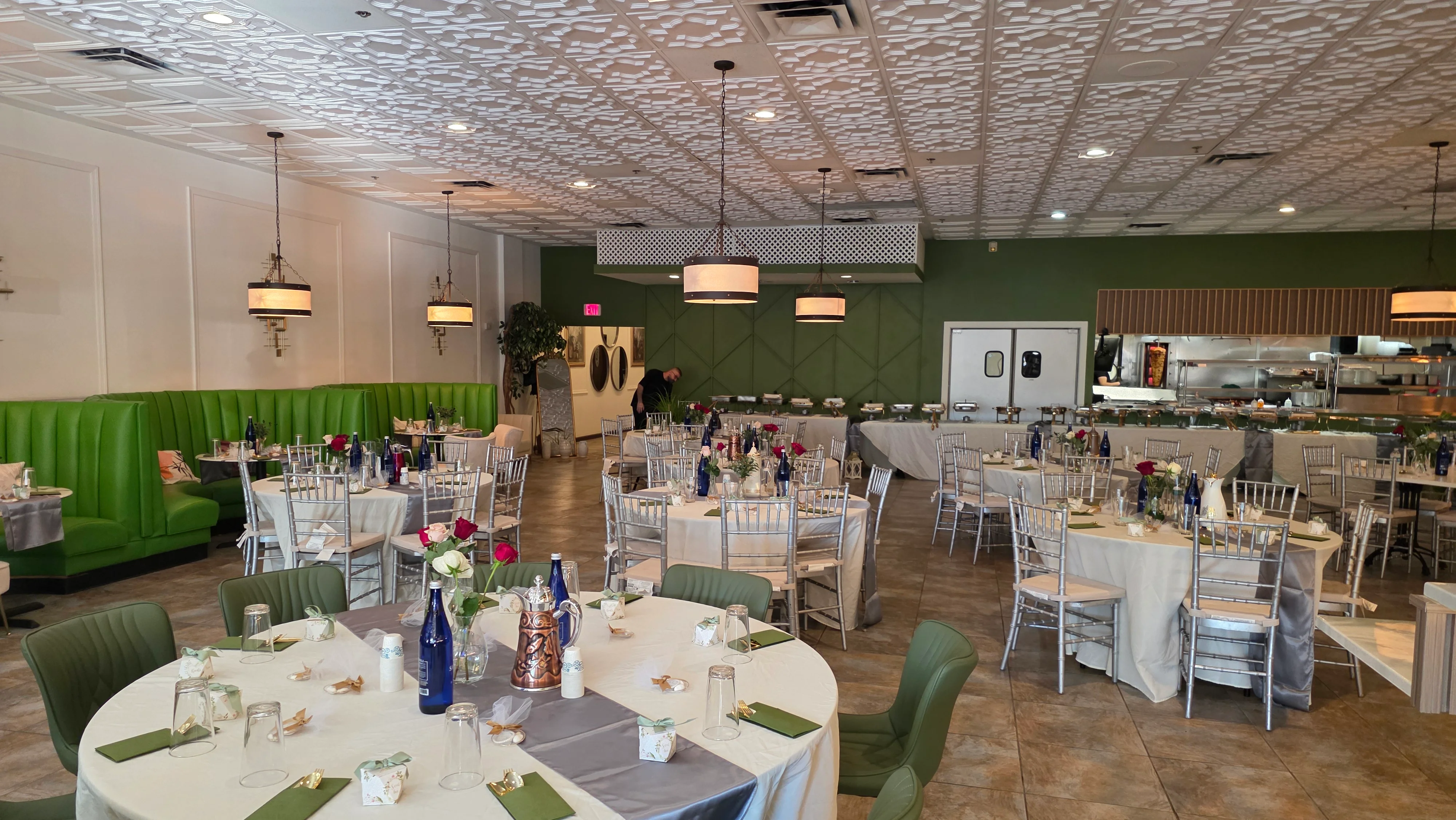 Elegant restaurant interior with green booths and floral table settings