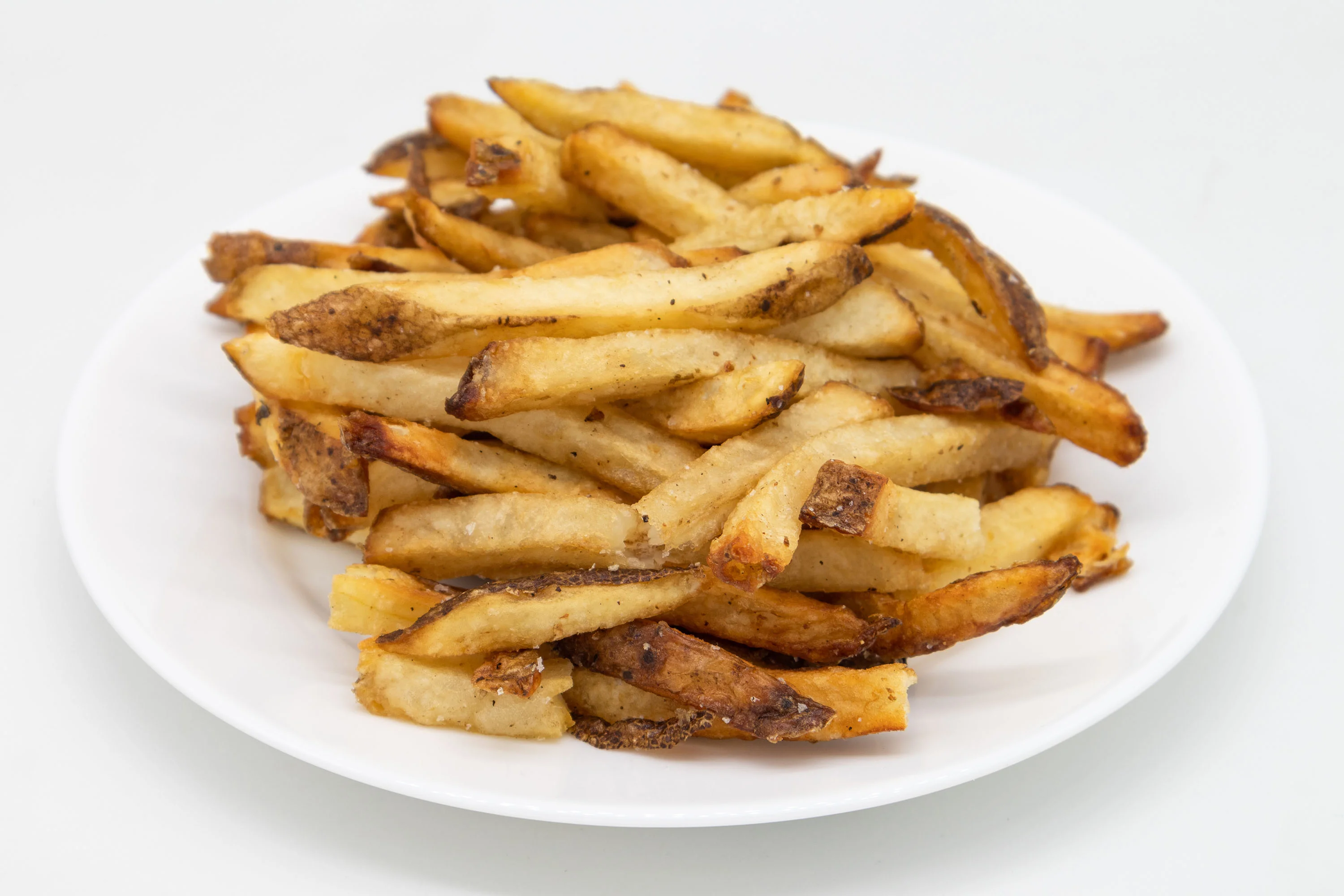 Crispy French fries served on a white plate
