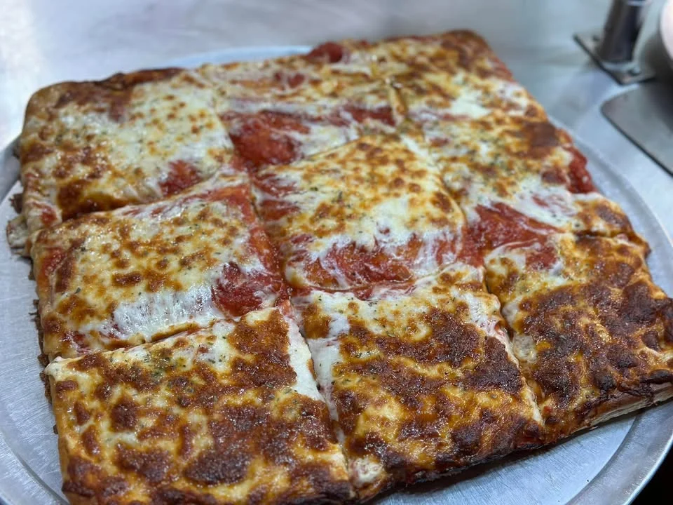Sicilian-style pizza with golden cheese and rich tomato sauce