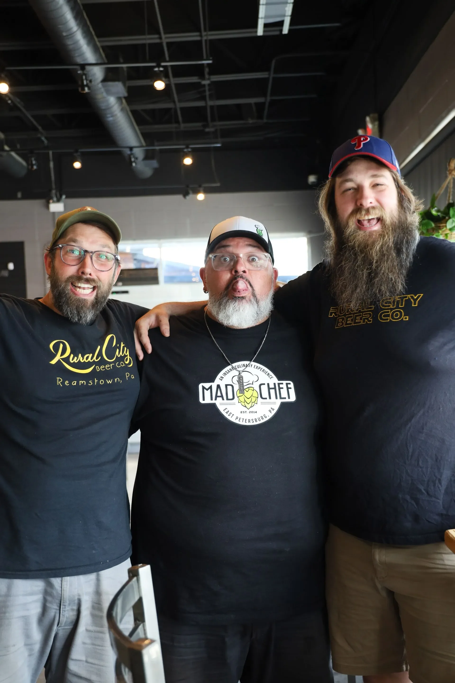 Three chefs posing playfully in a modern restaurant setting