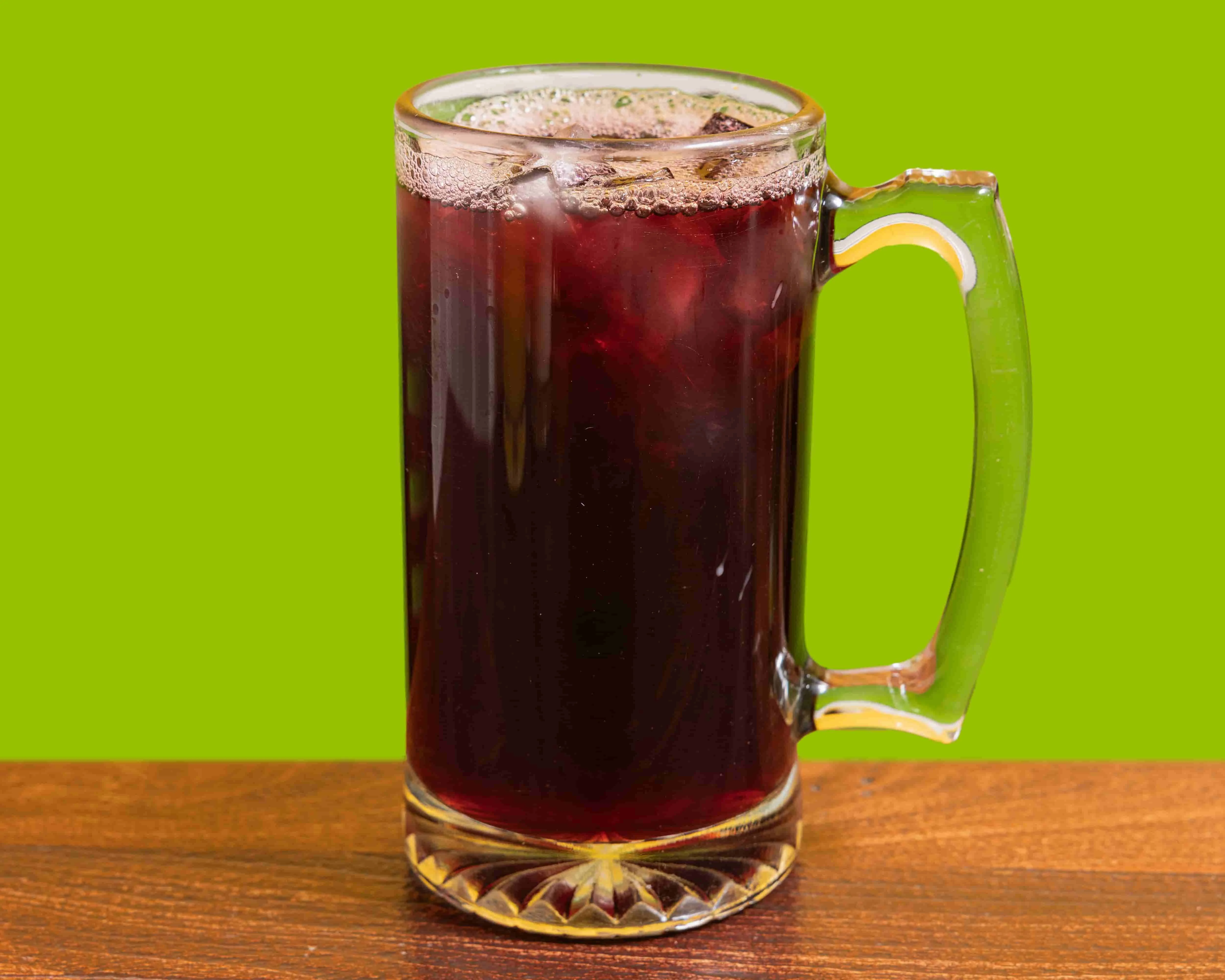 Refreshing glass of iced hibiscus tea on a wooden table