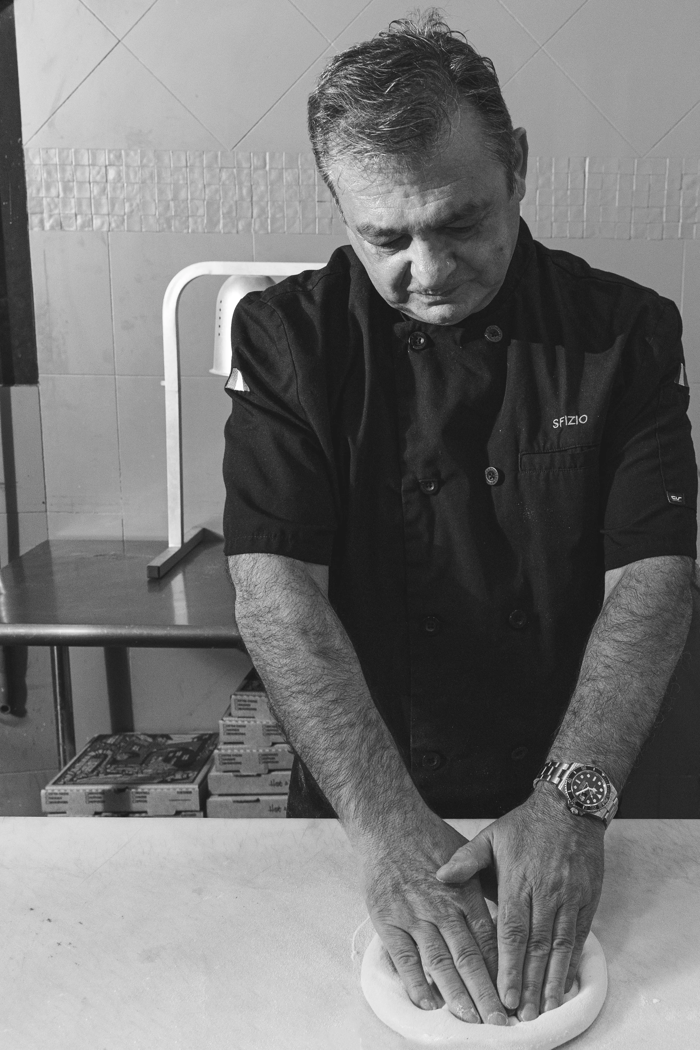 Chef making pizza in restaurant with fresh dough