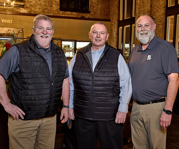 Three restaurant professionals in a cozy dining space