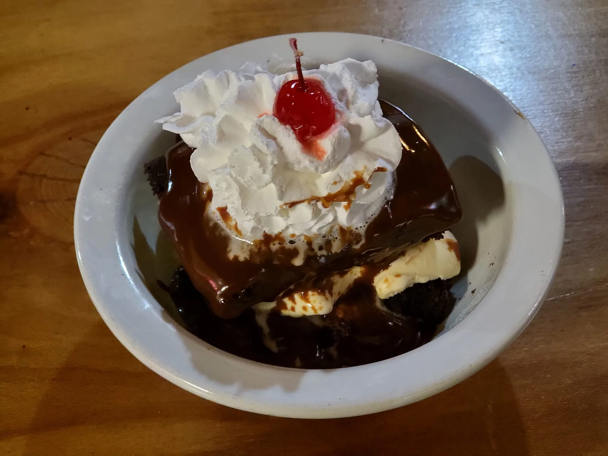 Decadent chocolate brownie sundae with whipped cream and cherry