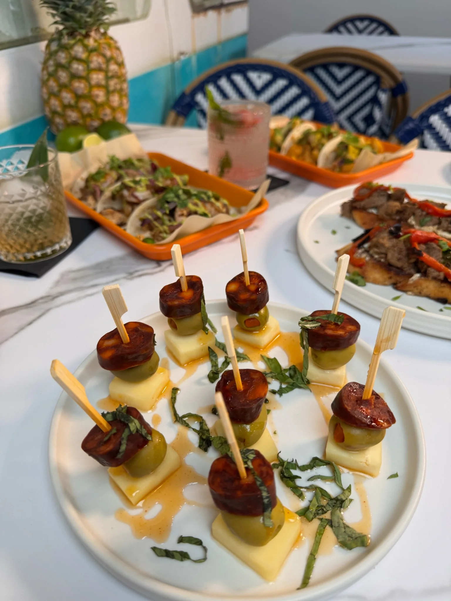 Spanish tapas featuring chorizo and cheese skewers with fresh herbs