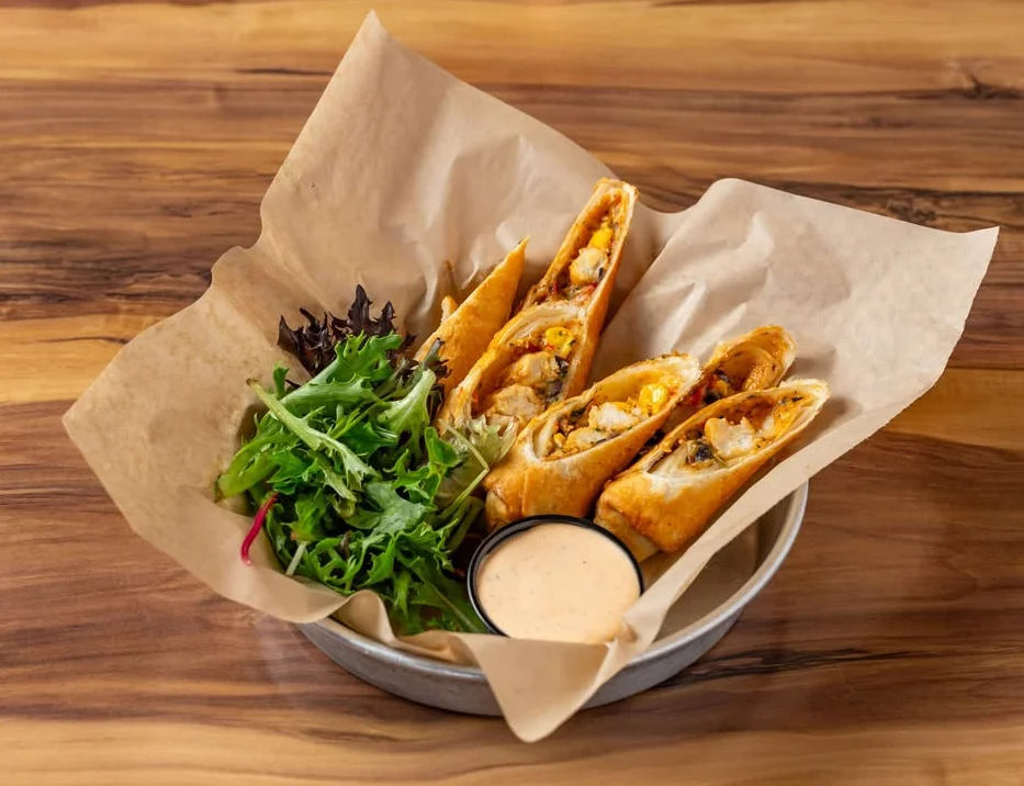 Crispy chicken flautas served with fresh greens and dipping sauce