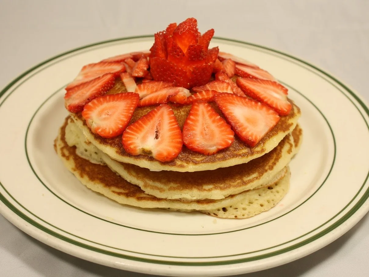 Fluffy pancakes topped with fresh strawberries