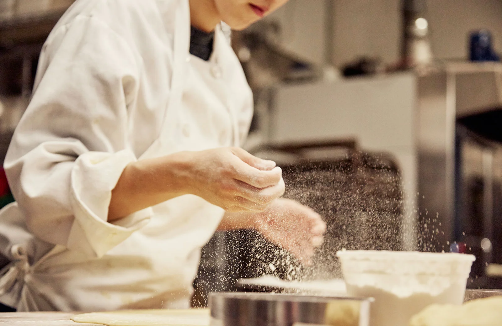 Chef preparing dough with flour in a professional kitchen