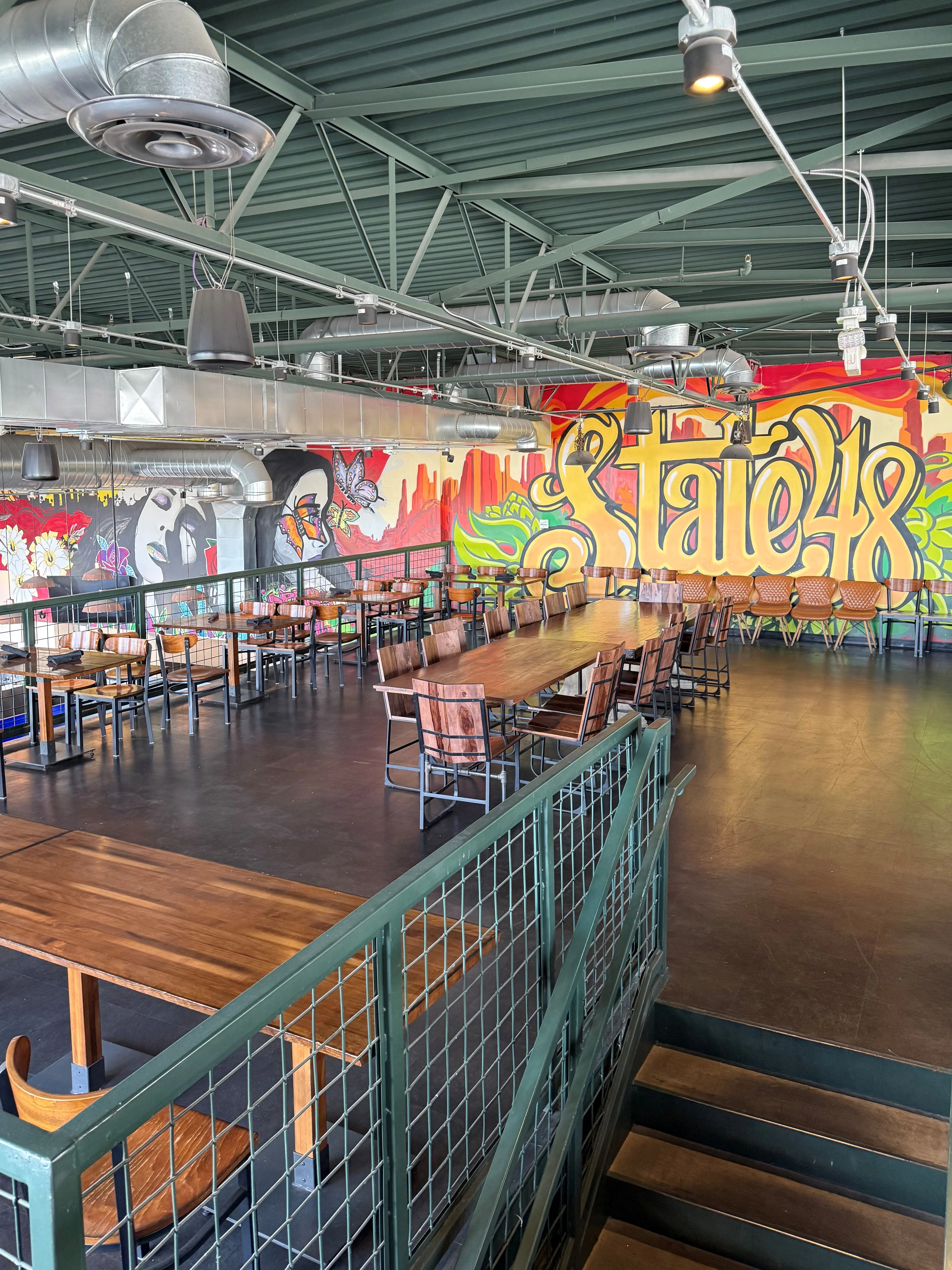 Modern restaurant interior with vibrant mural and spacious seating