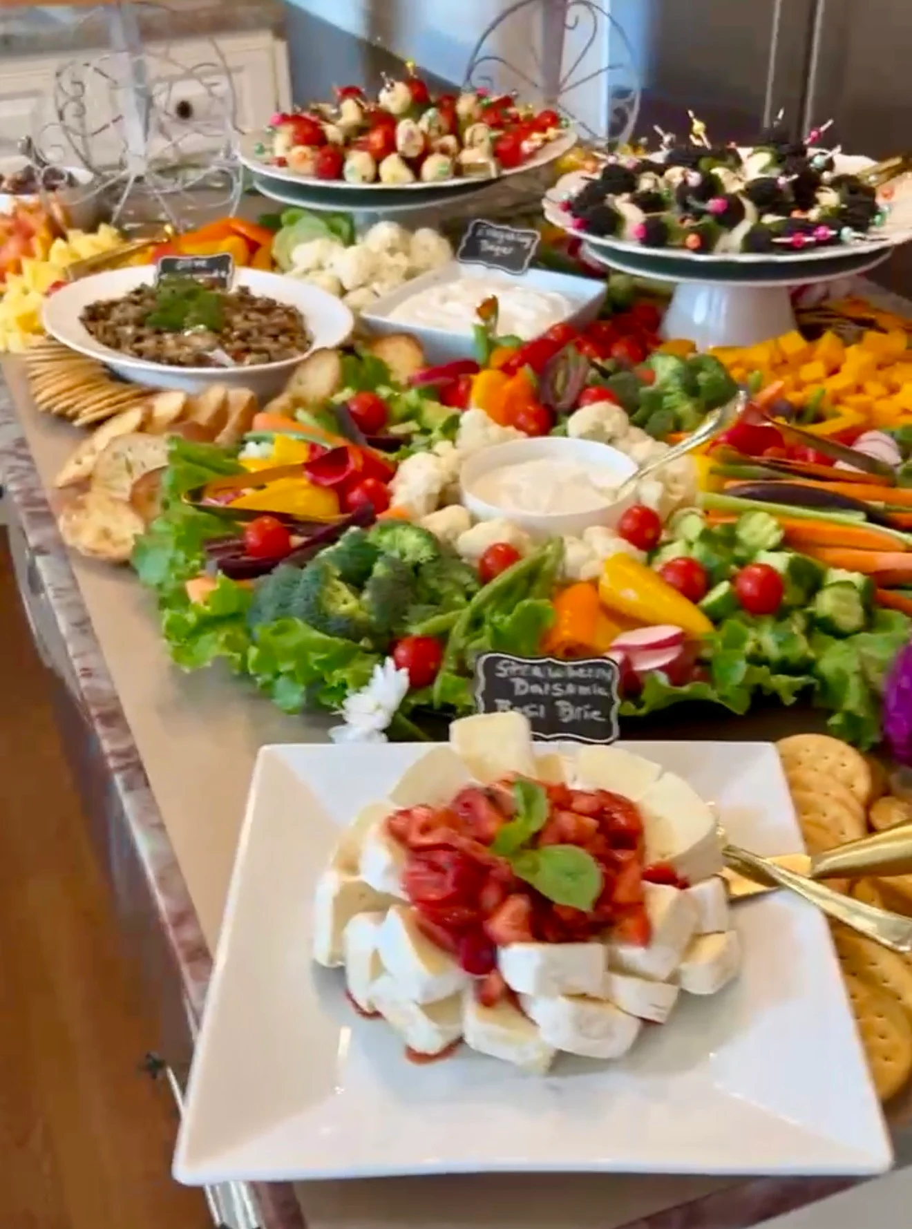 A colorful spread of appetizers, including vegetables, cheese, and fruits.