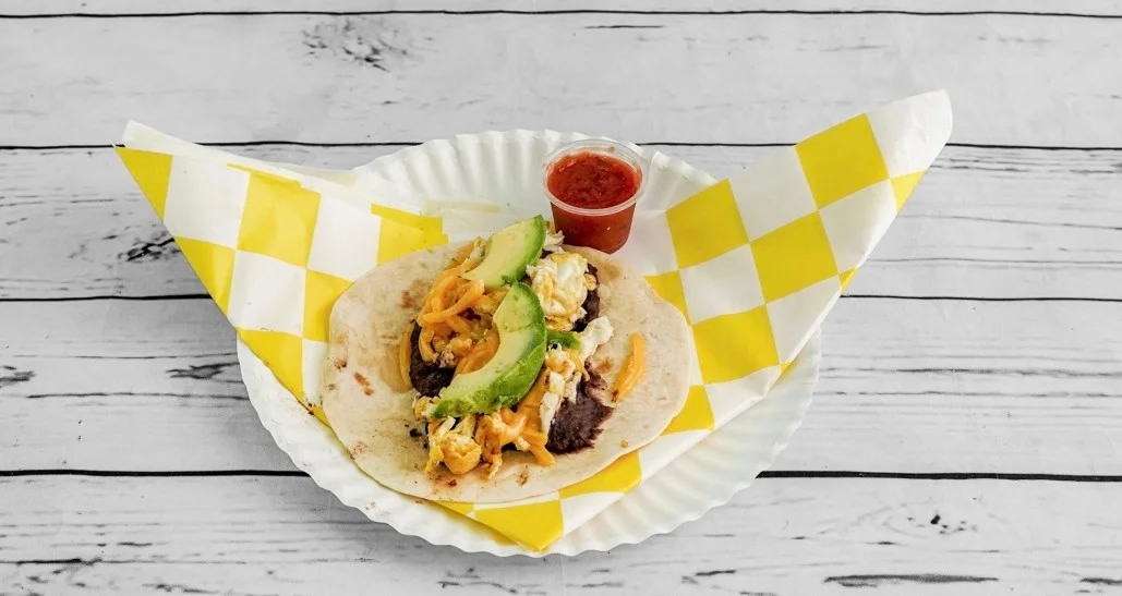 Mexican breakfast taco with scrambled eggs, avocado, beans, and salsa