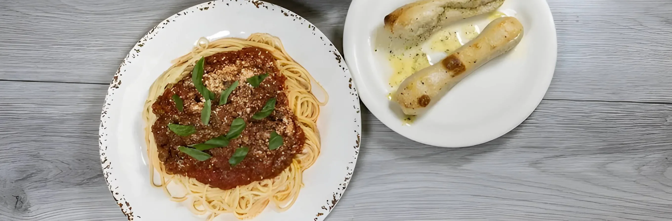Classic spaghetti with marinara sauce and garlic bread on a rustic table