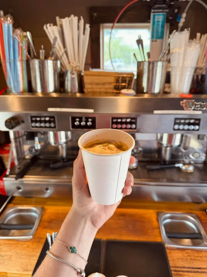 Barista holding a cup of espresso at a coffee shop