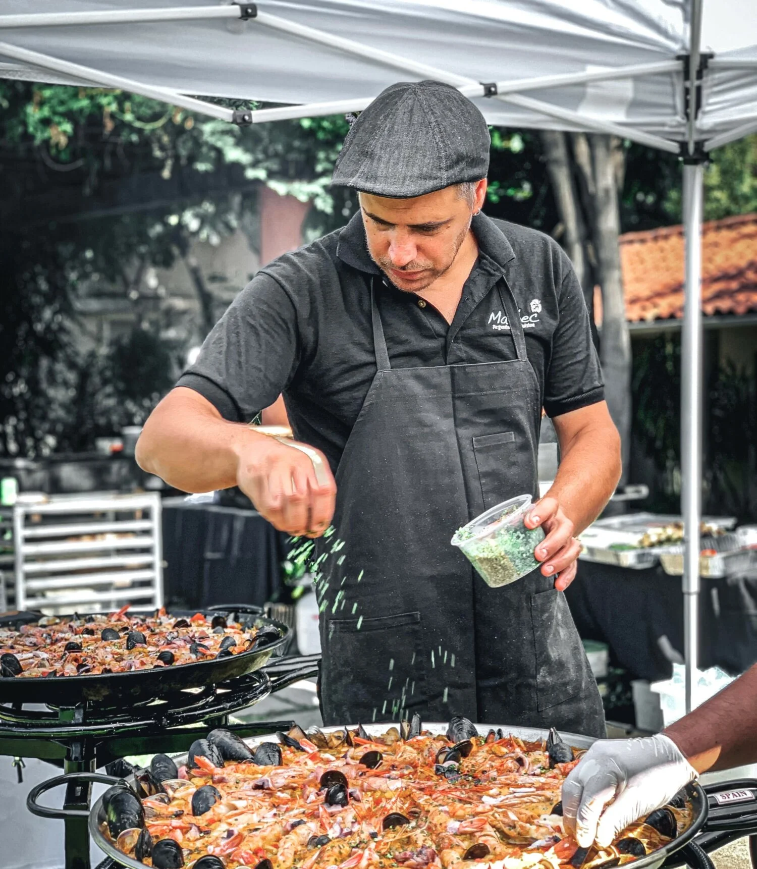 Chef preparing traditional Spanish paella outdoors