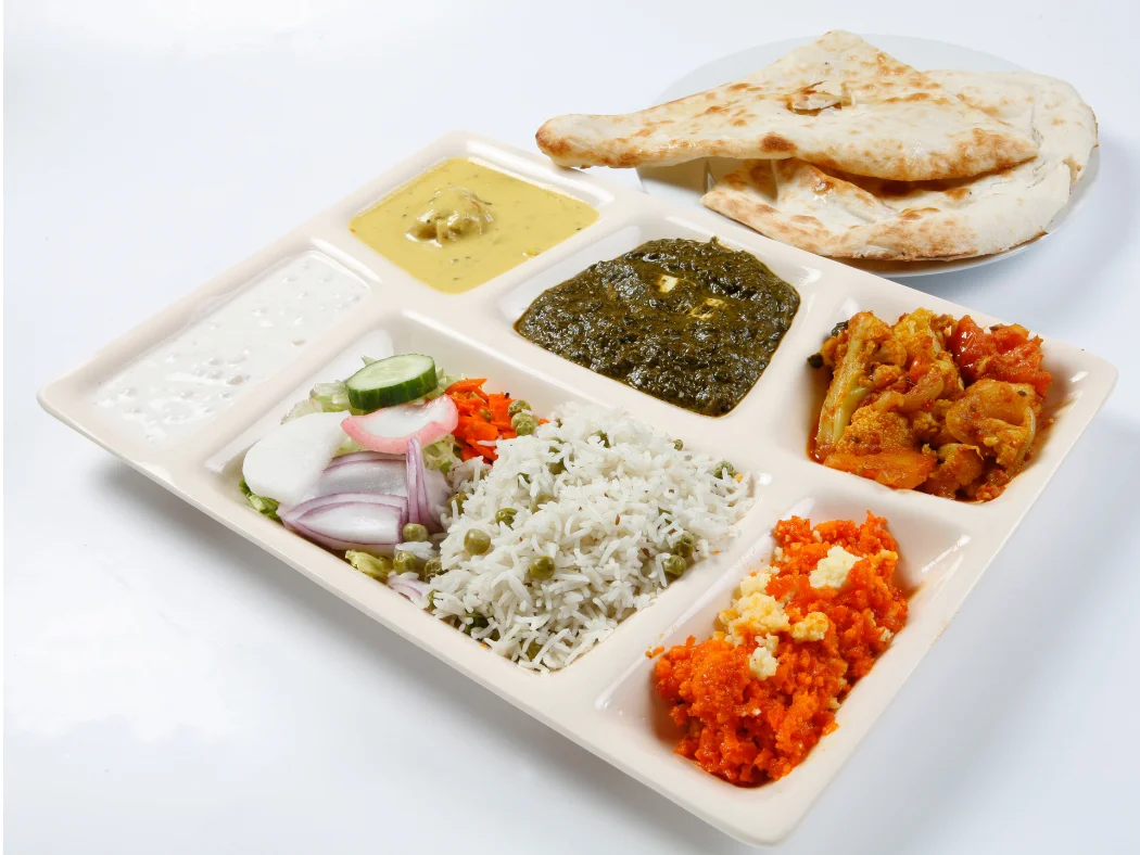 Traditional Indian thali with assorted curries and naan bread