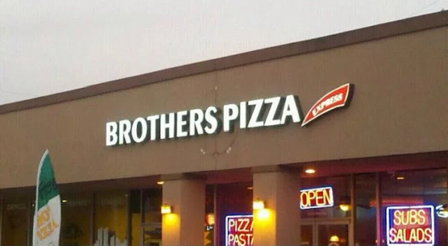 Brothers Pizza restaurant exterior with neon signs