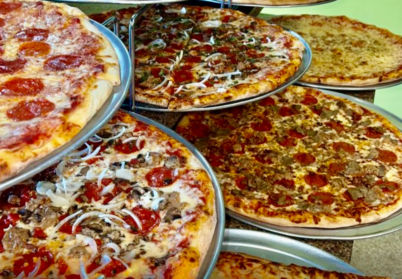 Variety of delicious pizzas in a pizzeria display