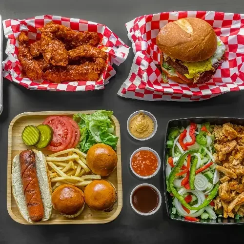 American comfort food platter with wings, burger, and hot dog