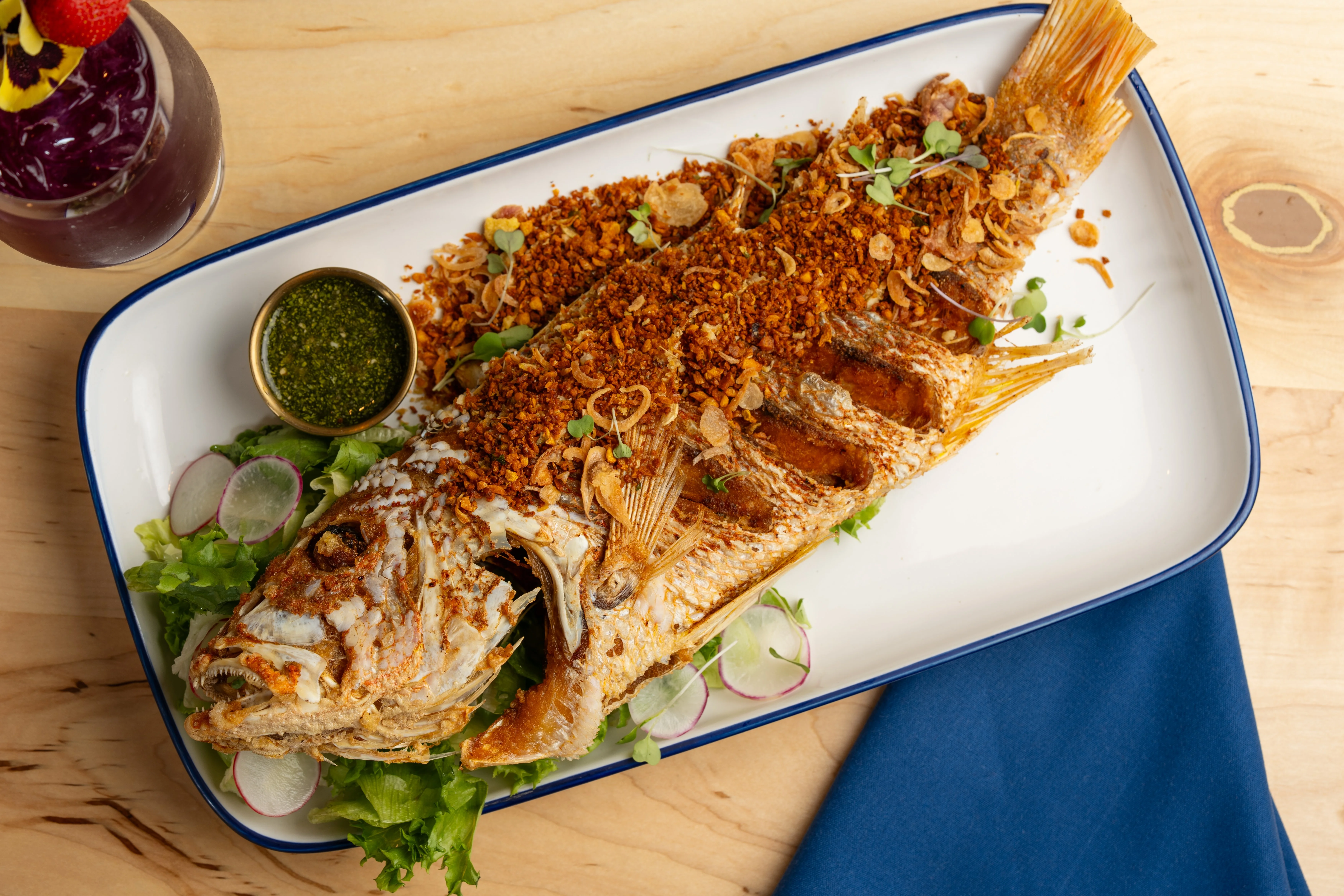 Crispy whole fish served with green sauce
