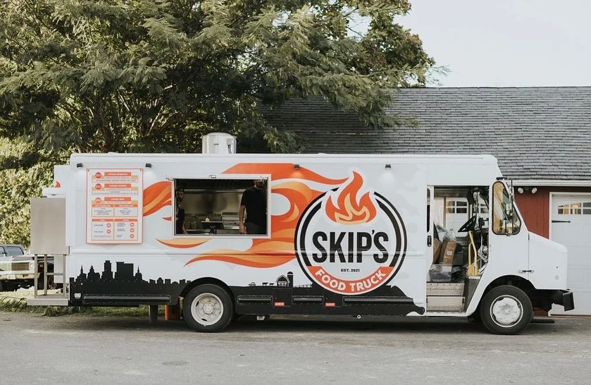 Skip's food truck with vibrant branding and menu display