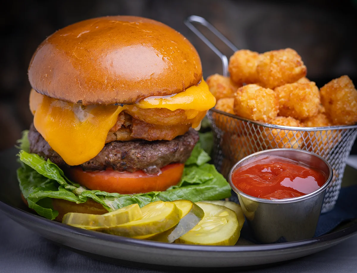 Juicy cheeseburger with tater tots and pickles
