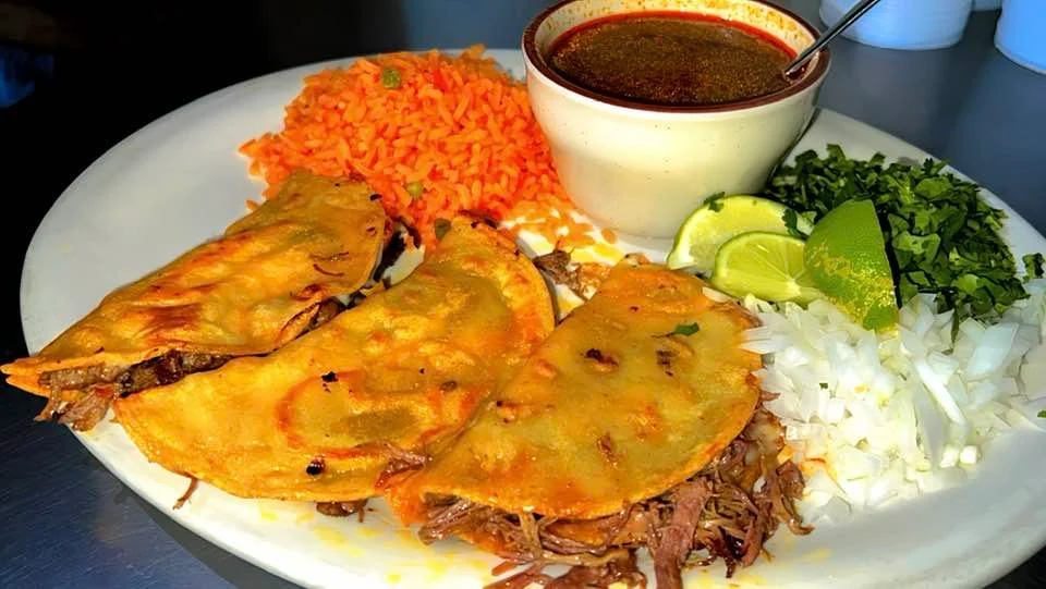 Plate of Mexican tacos with beef, rice, and salsa