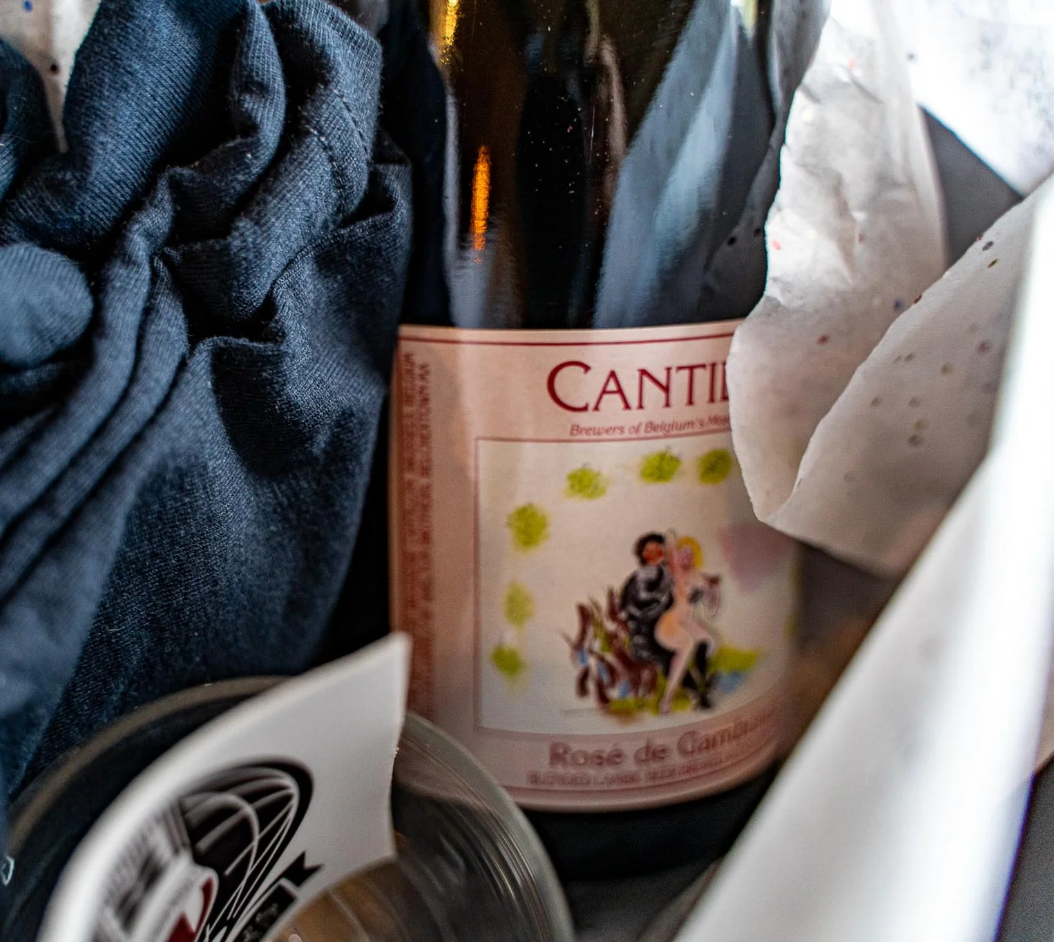 Bottle of Cantillon Rosé de Gambrinus surrounded by fabric and glassware