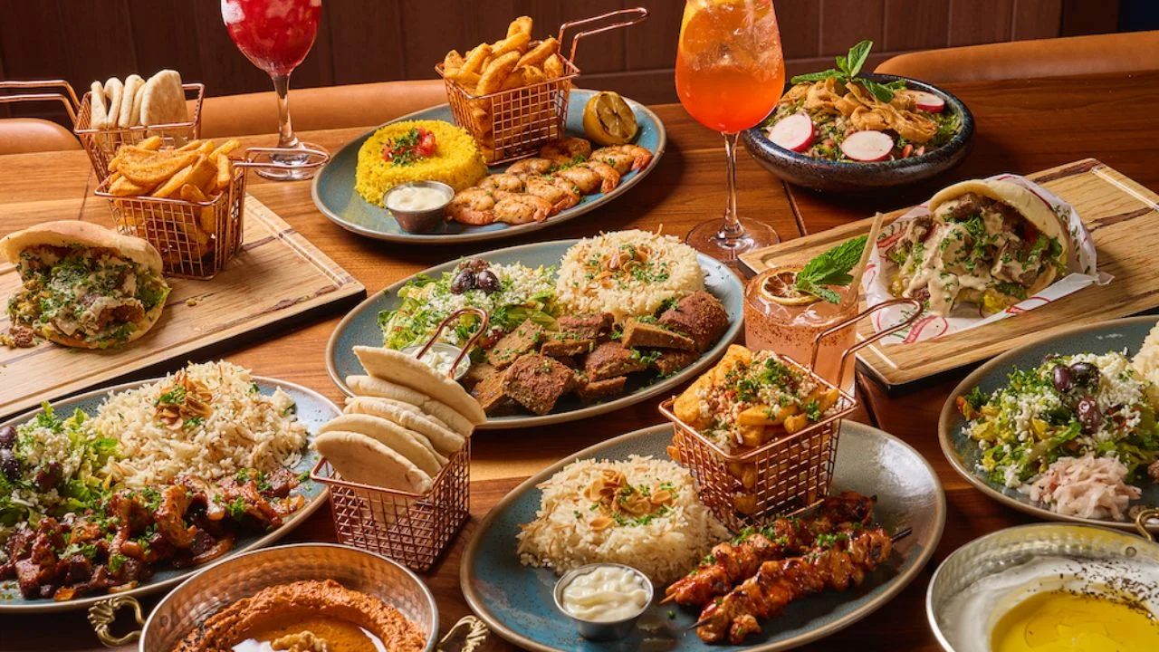 Assorted kebabs, rice platter, hummus, pita, and cocktails at Sufrat Mediterranean Grill.
