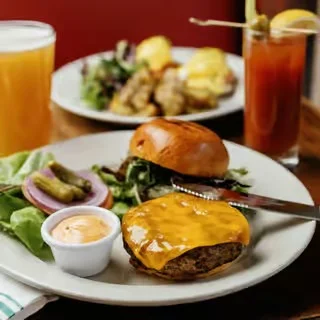 Juicy cheeseburger with side salad and drinks in a cozy restaurant setting