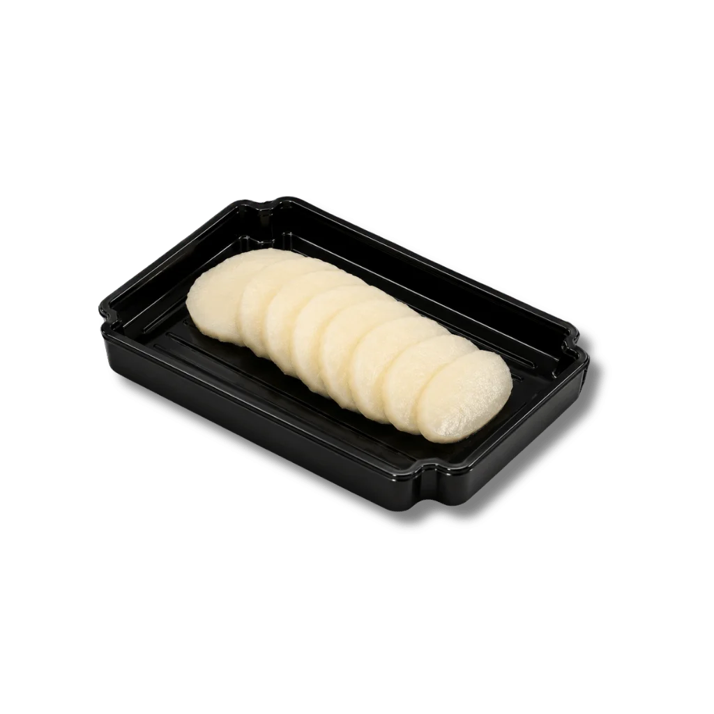 Sliced white food items arranged in a black container.