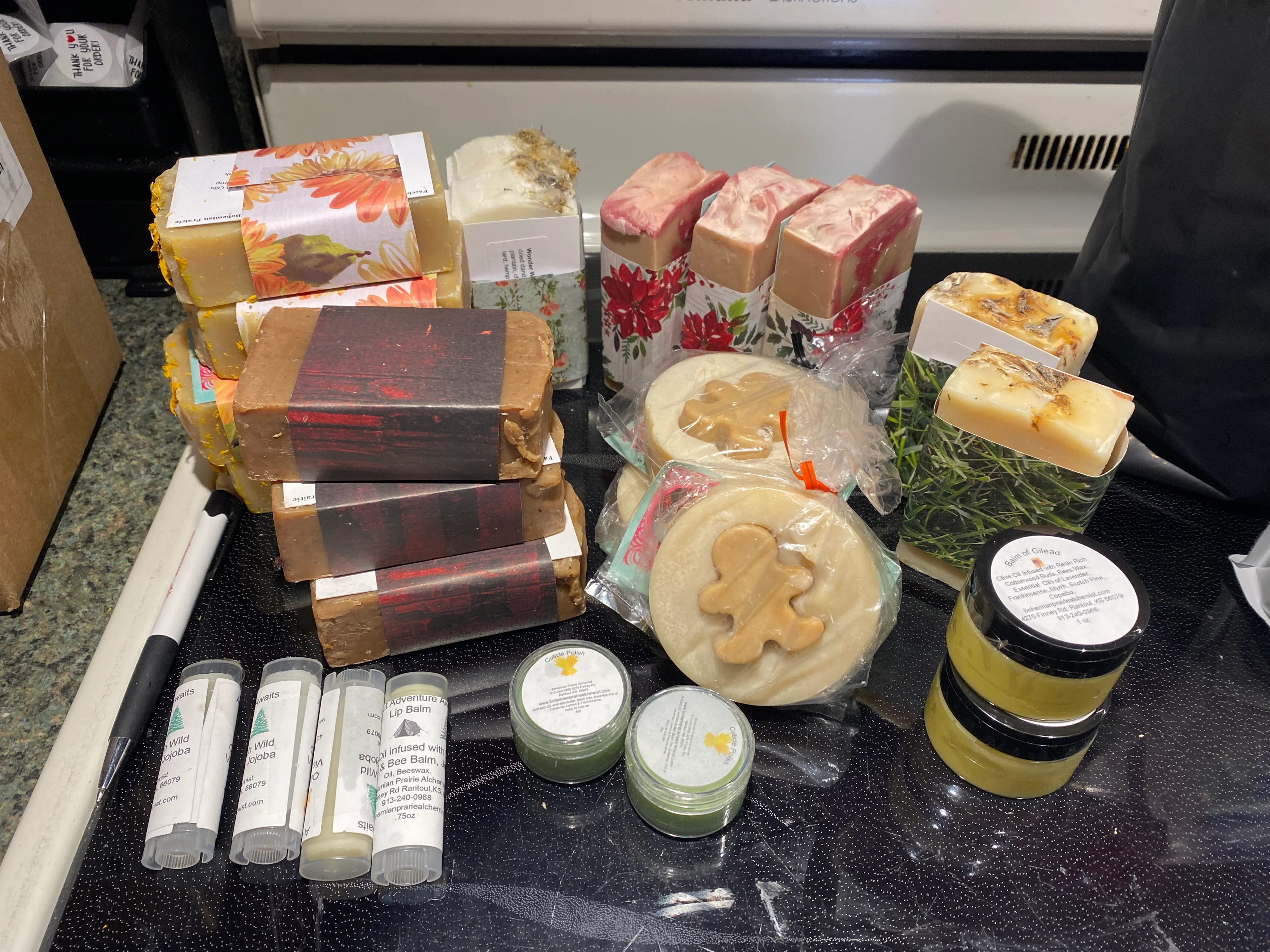 Variety of handmade soaps and lip balms on a countertop