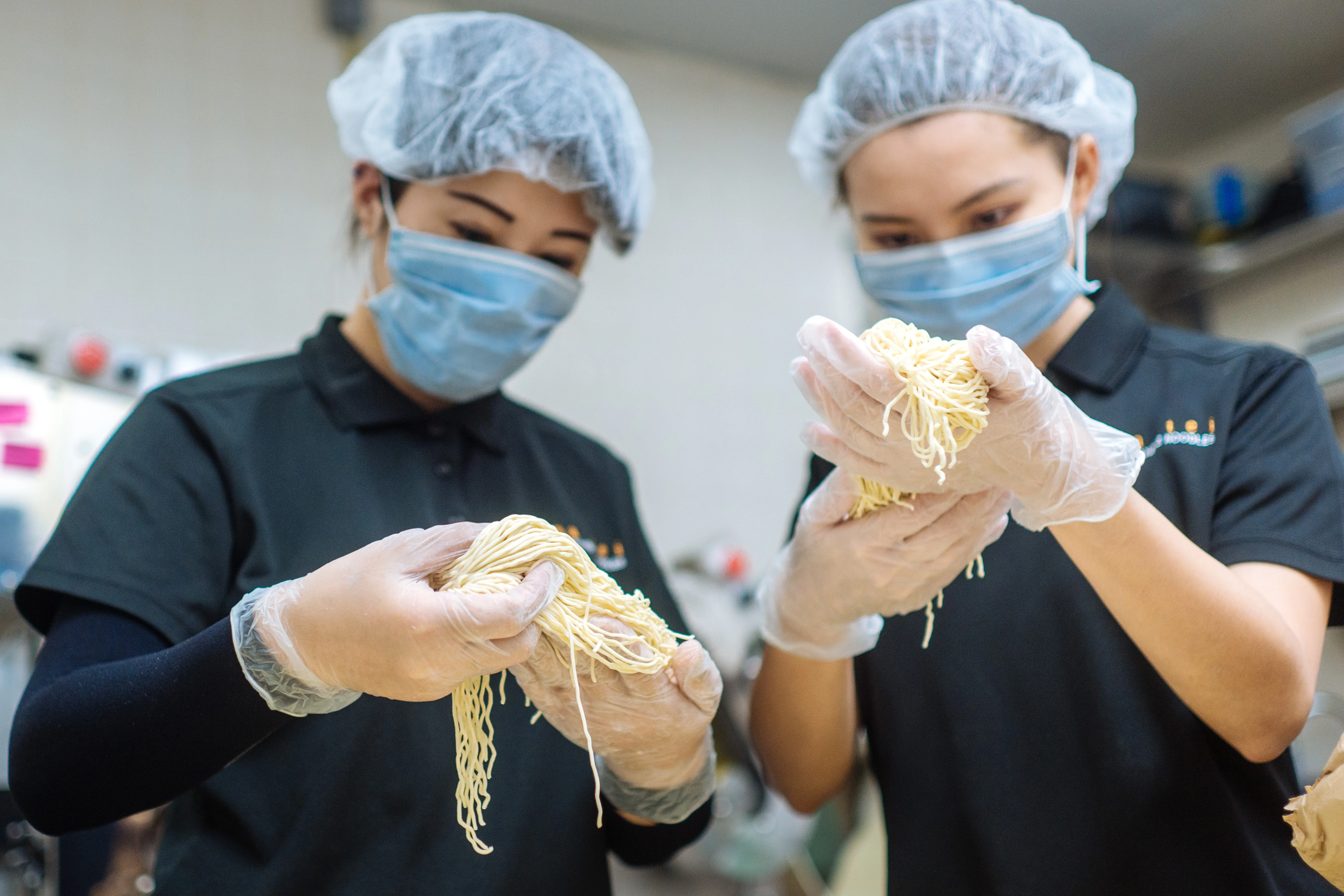 Chefs preparing fresh ramen noodles in a restaurant kitchen