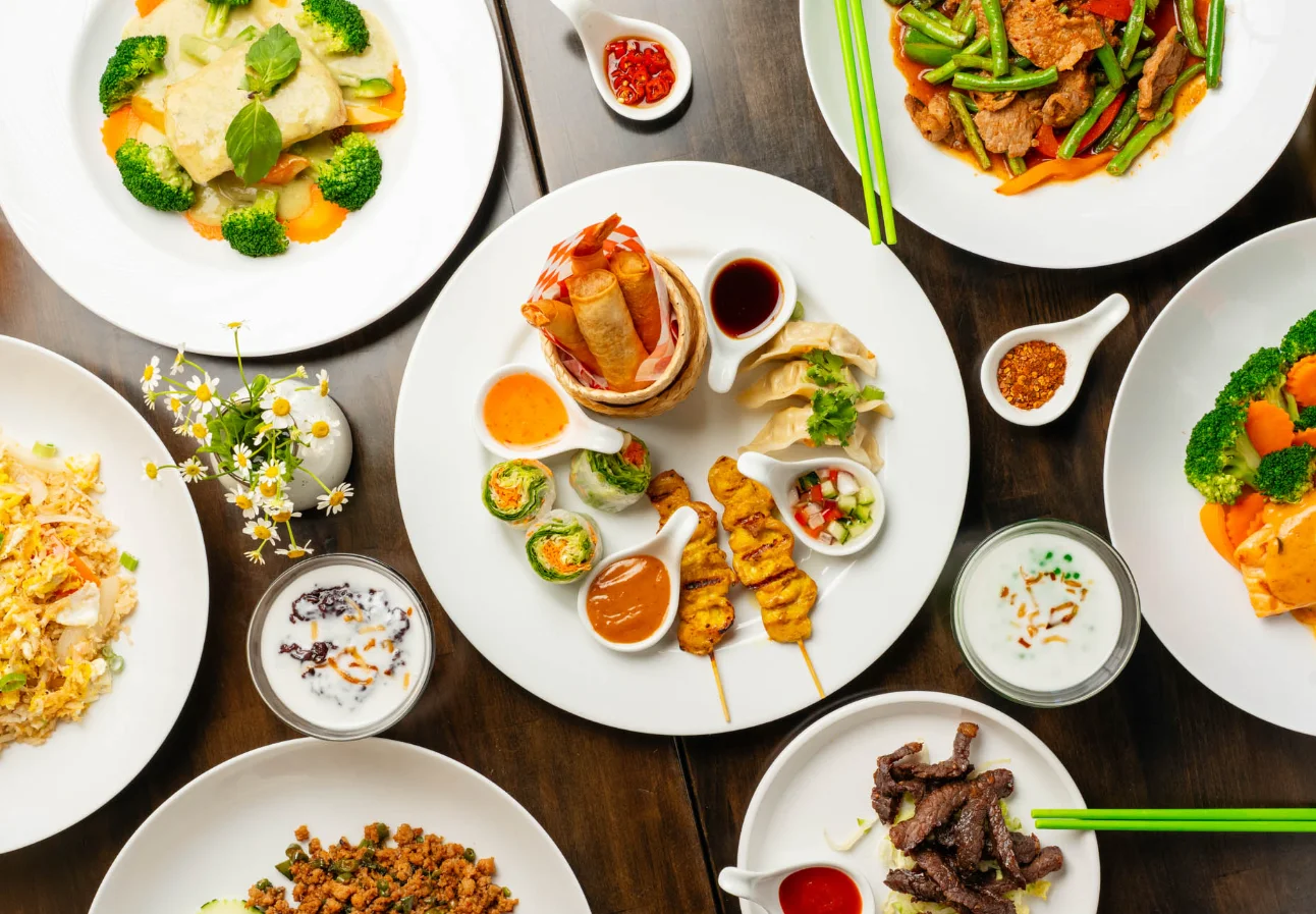 Assorted Thai appetizers and dishes on a wooden table