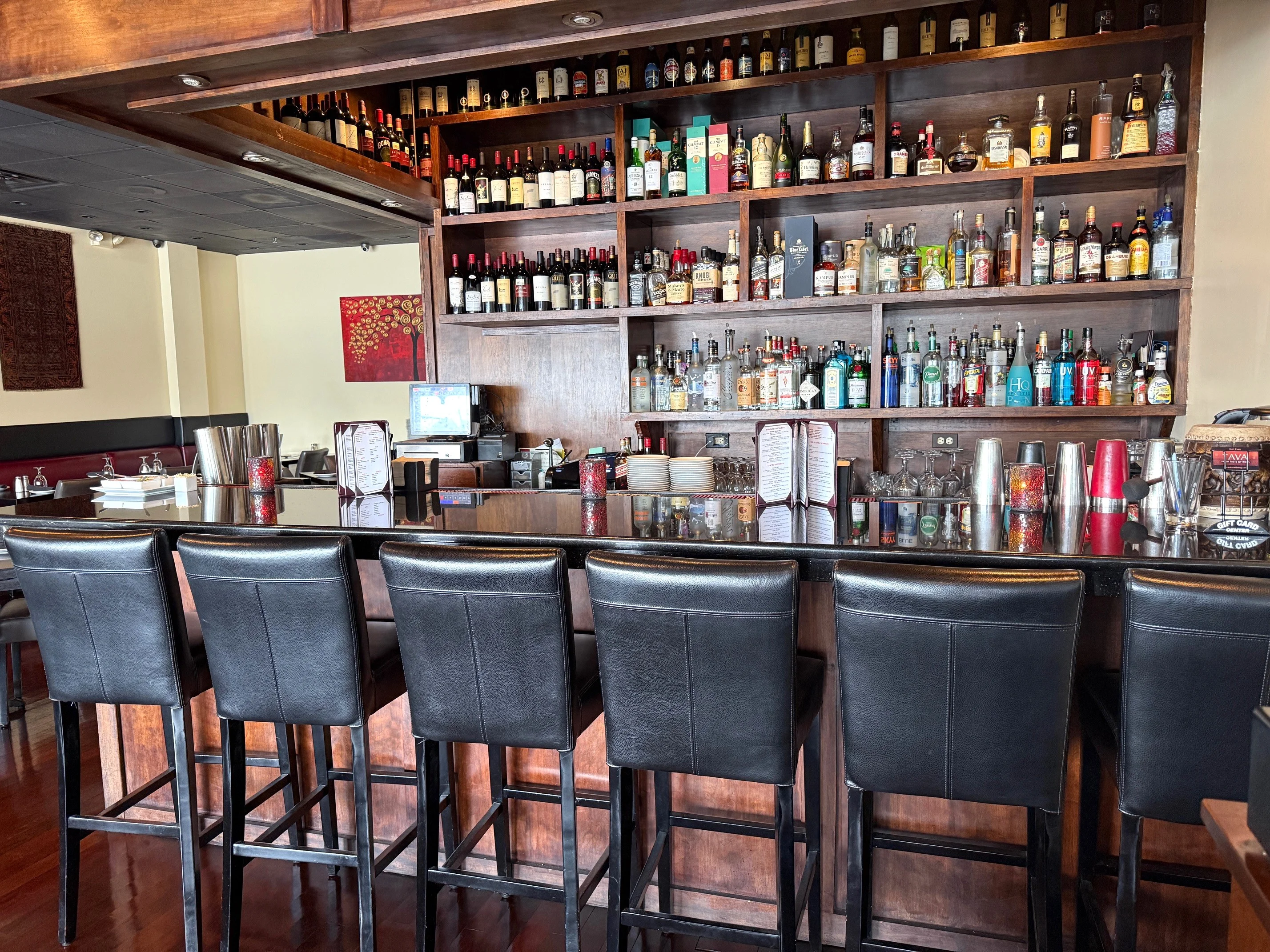 Modern bar counter with a variety of spirits and seating