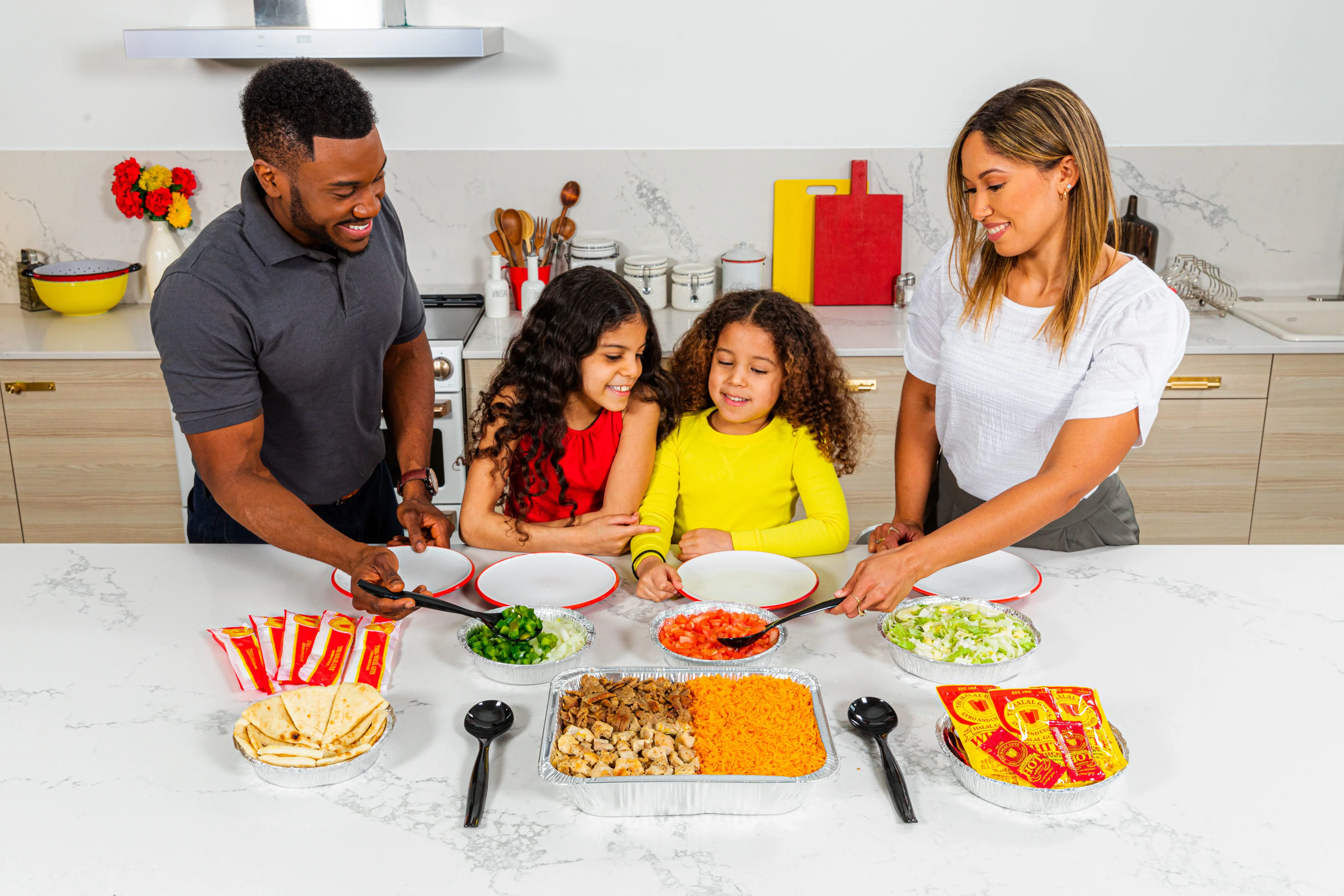 Family preparing a taco bar with fresh toppings