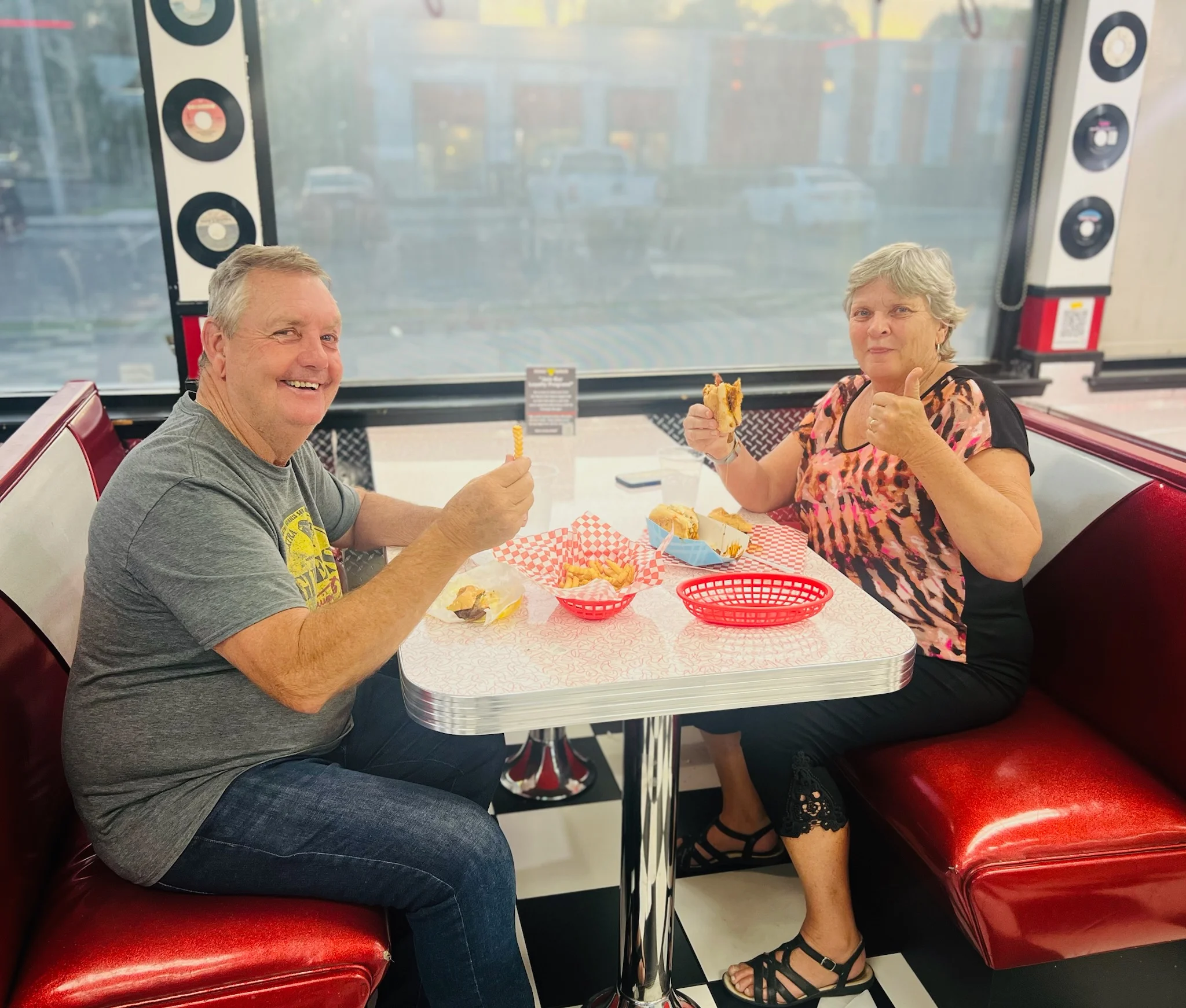 Couple enjoying burgers and fries in a retro diner setting